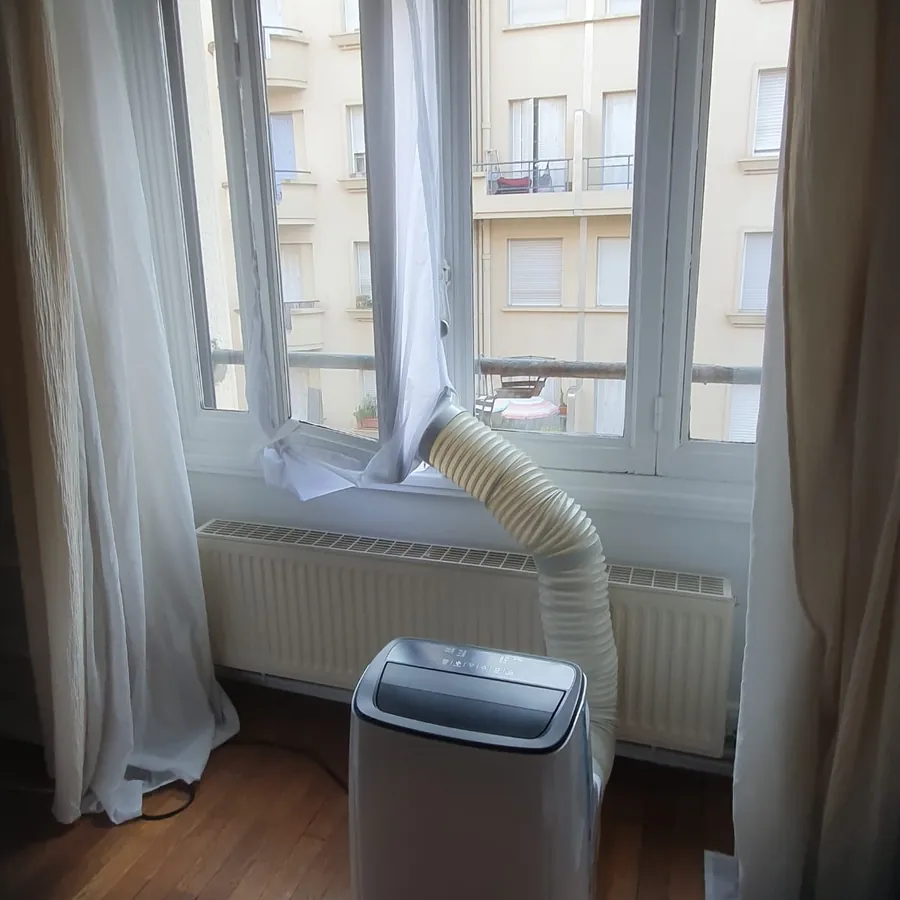 Climatiseur mobile en fonctionnement, gaine d'évacuation raccordée à la fenêtre – LouerMaClim